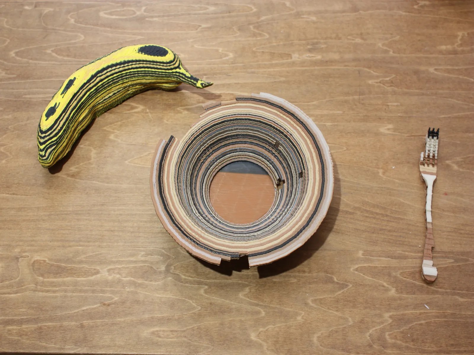 Sculpted banana, plate, and fork arranged on a wooden table